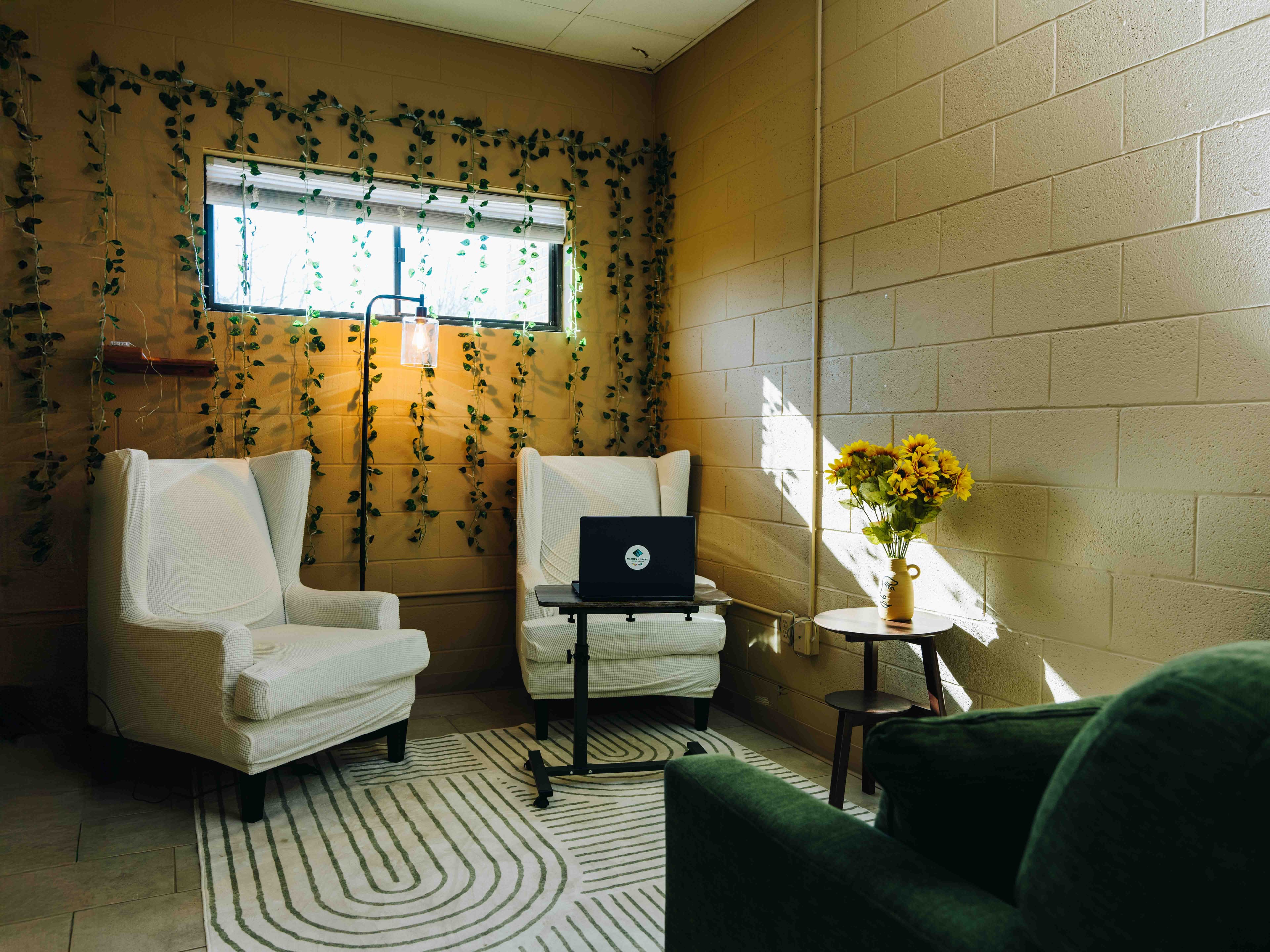 Individual therapy room with wingback chair and hanging vines