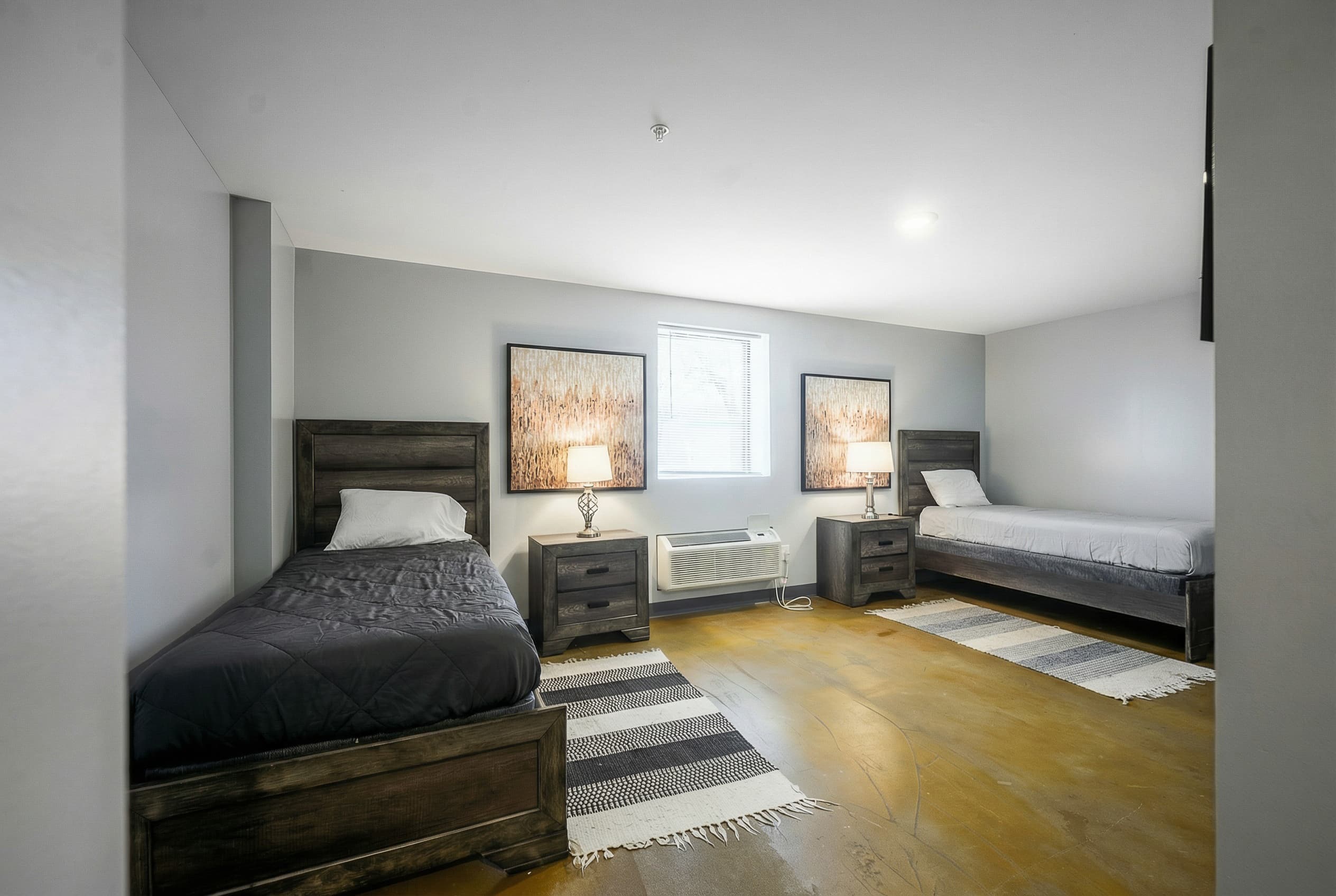 Residential bedroom with twin beds and warm furnishings at Natural State Recovery